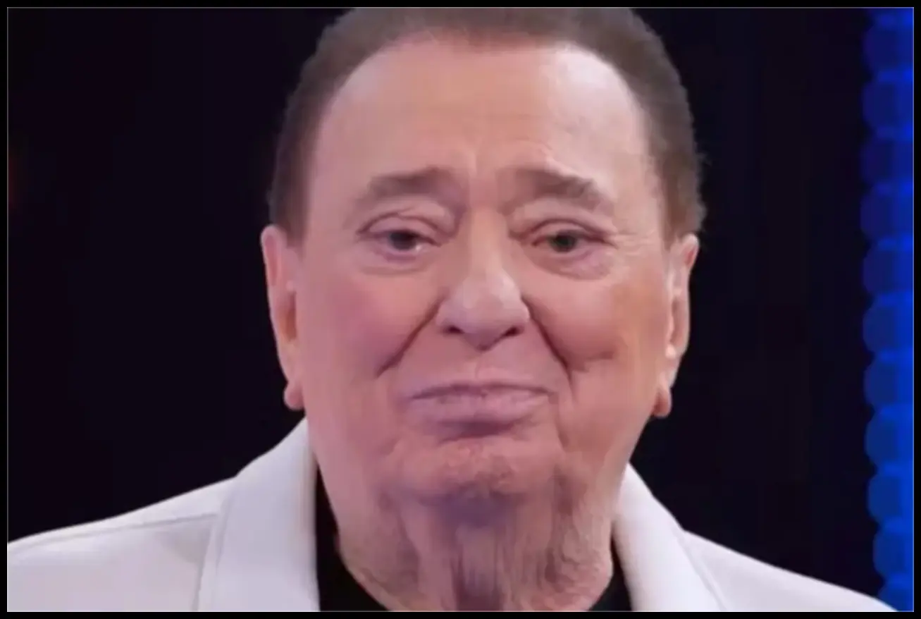 Raul Gil, o ícone da televisão brasileira, sorrindo e esbanjando carisma em seu palco.